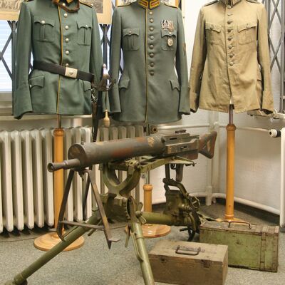Bild vergrößern: Nach dem 1. Weltkrieg: Uniformen der Reichswehr, verschiedene Truppenteile. Im Vordergrund Maschinengewehr-Attrappe (Übungsgerät)