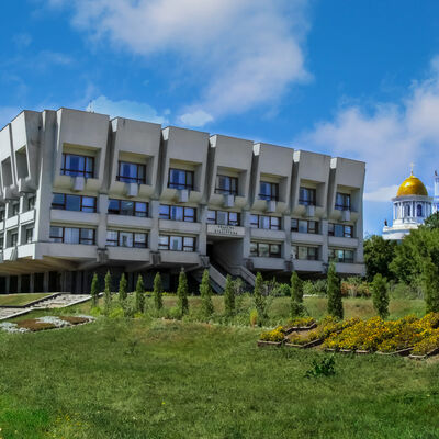 Sumy Regional Universal Scientific Library vor dem Hintergrund von Kuppeln und Türmen der Verklärungskathedrale.