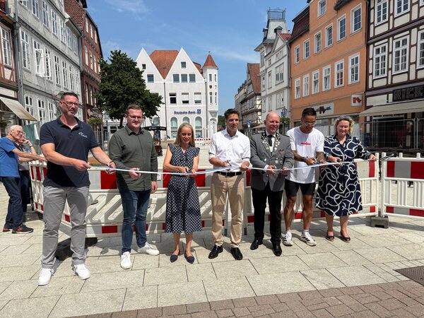 Bild vergr&ouml;&szlig;ern: Mit dem symbolischen Durchschneiden des Bandes wurde der Markt er�ffnet (von links): Ron Wolter, Ingenieurgesellschaft Heidt+Peters mbH, Felix Bonecke, Ing. Staatz Tiefbau GmbH, Stadtbaur�tin Elena Kuhls, OB Nigge, Oberster Hauptschaffer Norbert Sch�pp, Anh Duc Nguyen, Inhaber Ricetime, und Erste Stadtr�tin Nicole Mrotzek.
