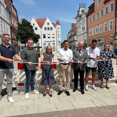 Mit dem symbolischen Durchschneiden des Bandes wurde der Markt er&ouml;ffnet (von links): Ron Wolter, Ingenieurgesellschaft Heidt+Peters mbH, Felix Bonecke, Ing. Staatz Tiefbau GmbH, Stadtbaur&auml;tin Elena Kuhls, OB Nigge, Oberster Hauptschaffer Norbert Sch&uuml;pp, Anh Duc Nguyen, Inhaber Ricetime, und Erste Stadtr&auml;tin Nicole Mrotzek.