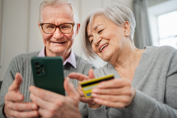 &Auml;lteres Paar, Mann und Frau, mit einem Smartphone und einer Kreditkarte.