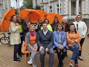 Niedrigschwelliges Hilfsangebot f&uuml;r Frauen in Notsituationen: die orangefarbene Bank mit ihren Initiatorinnen und Initiatoren.  